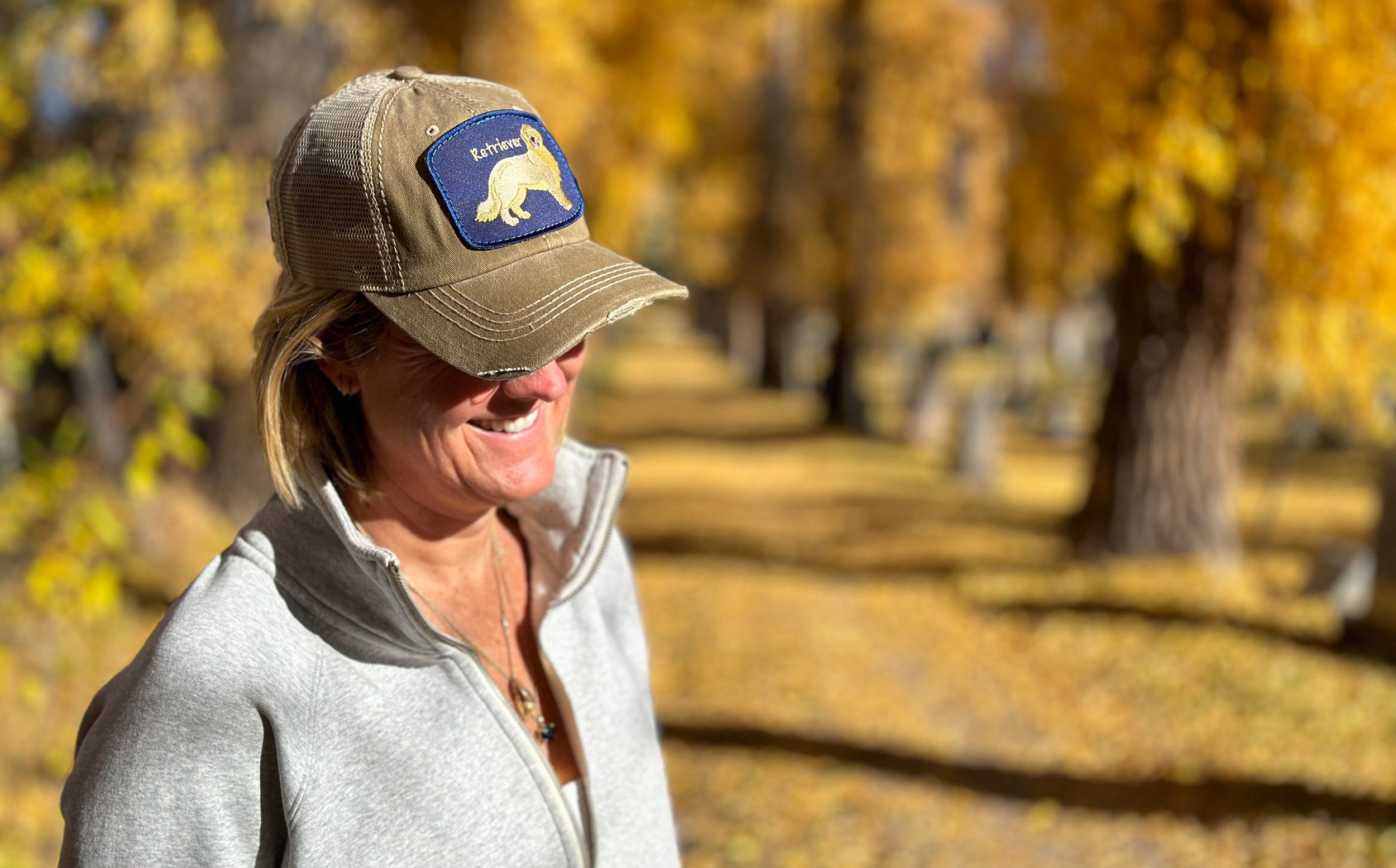 Woman wearing a baseball hat with Golden Retriever on it